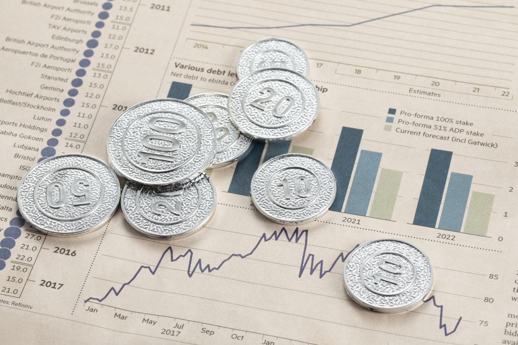 high-angle-shot-silver-coins-pages-with-bar-graphs.jpg